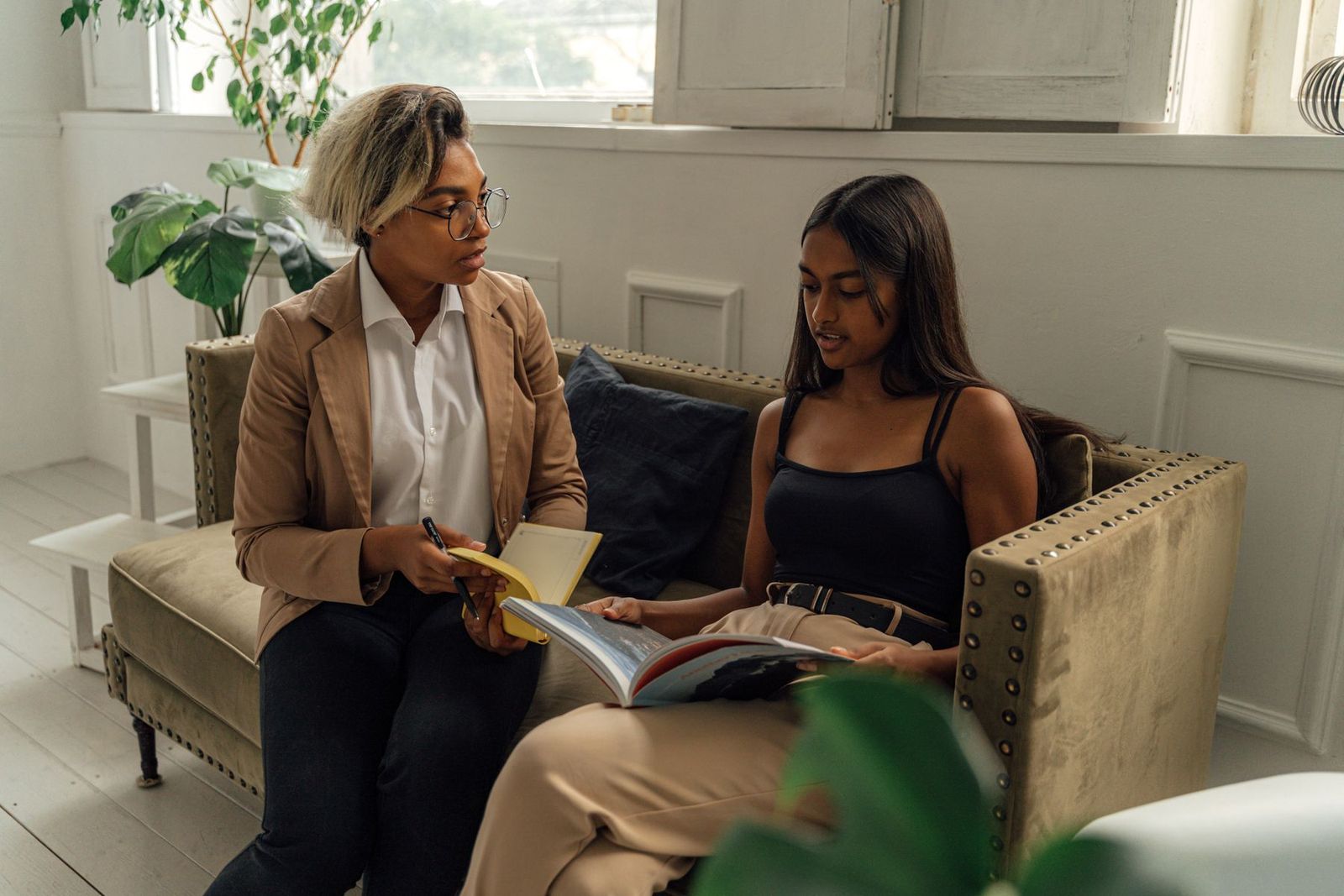Lehrerin und Schüler besprechen gemeinsam ein Buch