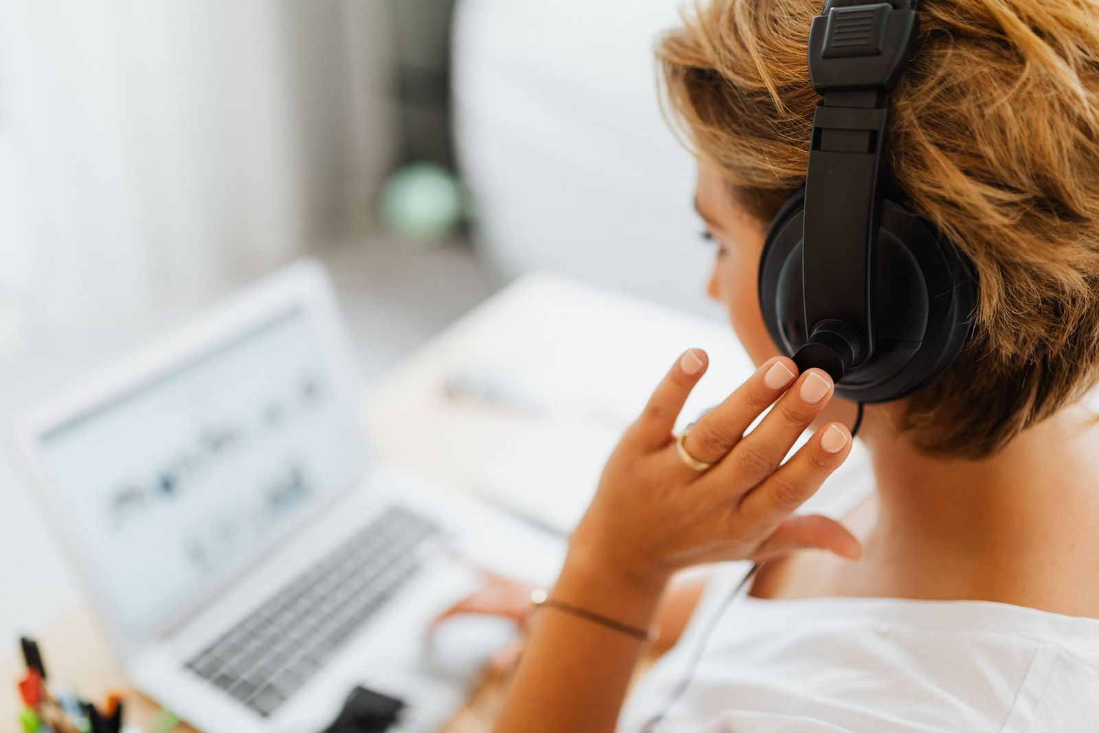 Lernende zu Hause mit Kopfhörern und Laptop im Videogespräch